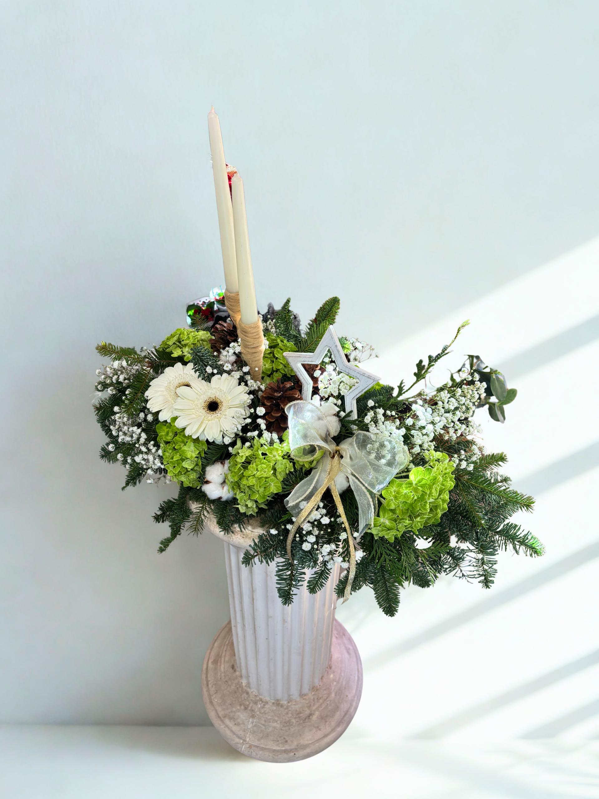 Centro de Navidad blanco y verde con dos velas, gerberas, hortensias, paniculata, piñas y abeto – Danka Floristas