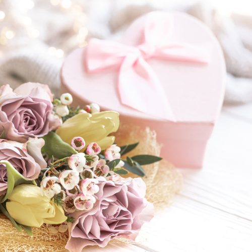 Spring composition with flowers and gift box on blurred background, concept of Mother's day, Women's day.